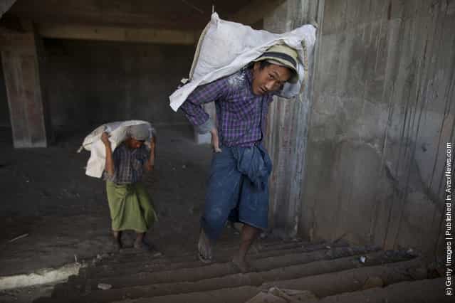 Burmese workers carry cement at a construction site for a new 140 room hotel