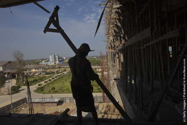 Burmese workers carry wood at a construction site for a new 140 room hotel