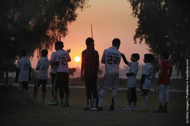 Children practice soccer at sunset in Baghdad, Iraq