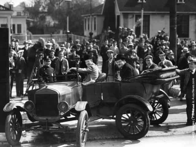 Spectators gather to watch the filming of County Hospital on location in Los Angeles. In the foreground are the Hal Roach comedians and stars of the production, Stan Laurel (1890 - 1965) and Oliver Hardy (1892 - 1957), 1924