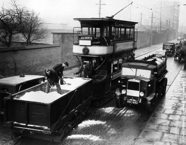 1936: Salt being spread on the street from a trailer fitted to a tram car in a test run in Manchester in case snow should fall