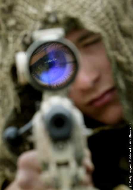 A British soldier from 3 Commando Brigade looks through the sight of his sniper rifle at Camp Gibraltar