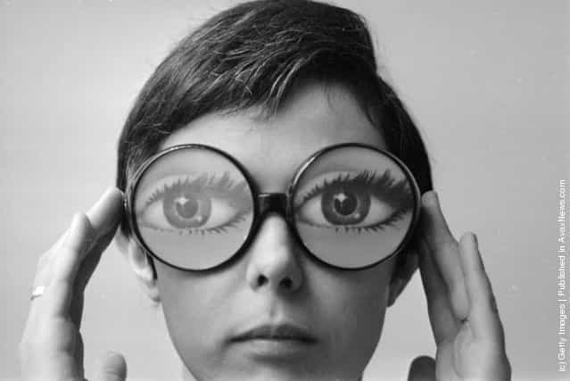 1969: Big round glasses magnify the eyes of the model wearing fashion glasses designed by Marly, a Paris optician
