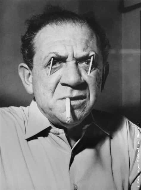 South African-born actor Sid James (1913 - 1976) uses matchsticks to prop up his eyebrows, 23rd December 1959