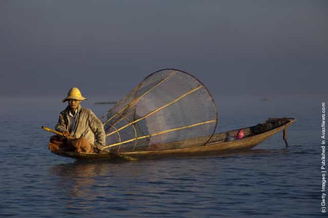 Intha leg rowing fishermen starts to fish in the early morning hours on Inle Lake in Myanmar