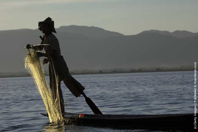 Intha leg rowing fishermen starts to fish in the early morning hours on Inle Lake in Myanmar