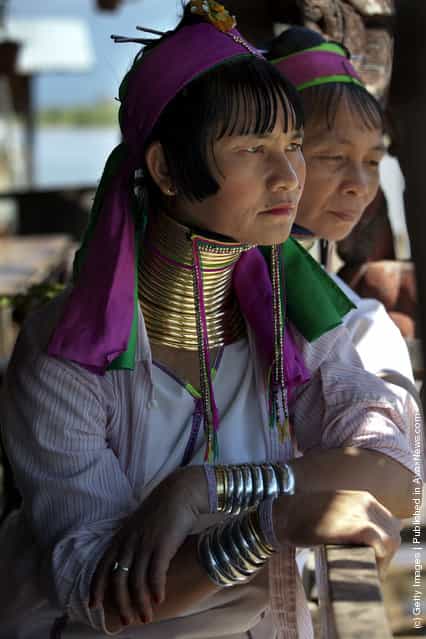 Burmese Long Neck wait for tourists to arrive at a handicraft shop on Inle Lake