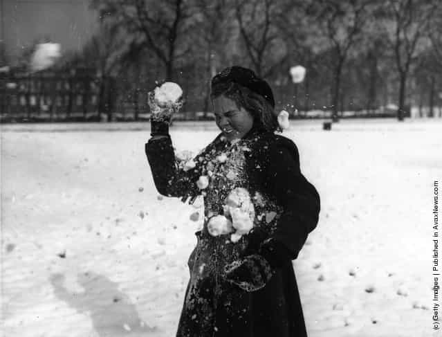 1954: A young girl being hit by a snowball whilst playing in St James Park, London, after a night of heavy snowfall