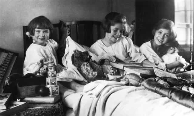 1925: Three girls on Christmas morning delighted with their gifts from Father Christmas