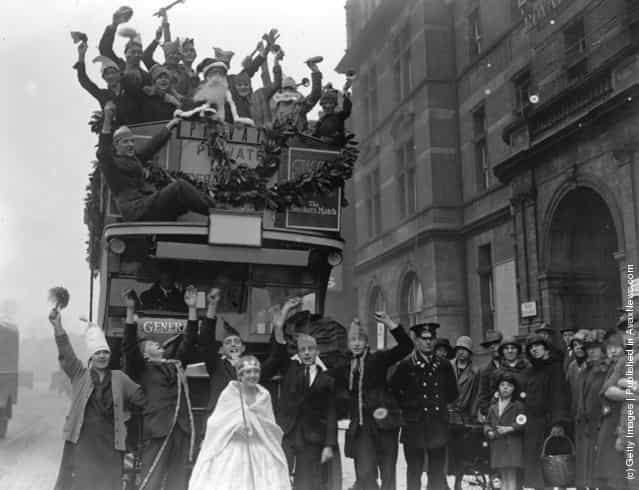 1926: Children from the Royal Caledonian School enjoying a festive Christmas pageant on an open top bus which is carrying Santa and his helpers through the streets
