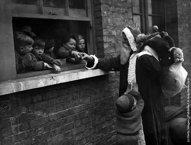 1931: Father Christmas delivering presents to the Childrens Aid and Adoption Society at Leytonstone, London