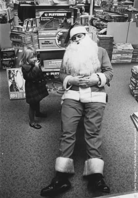 1976: A young girl finds Father Christmas asleep at Bourne And Hollingsworth store in Oxford street, London