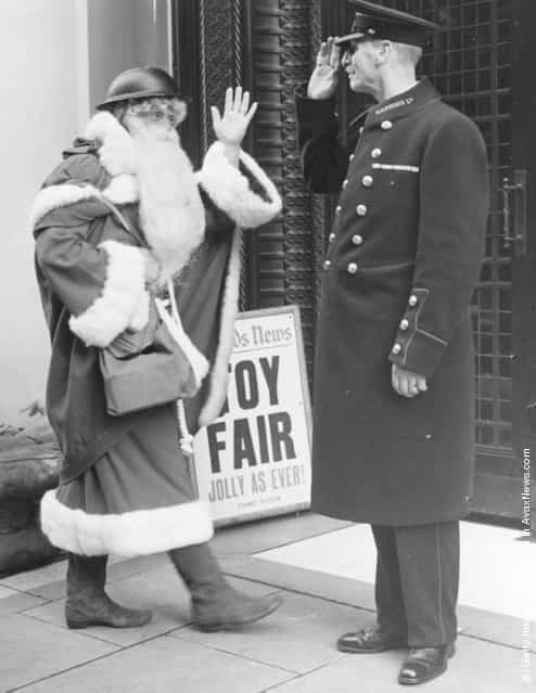 1939: Even Father Christmas follows the war time safety precautions as he arrives this year, complete with tin helmet, at Londons famous Brompton road store, Harrods