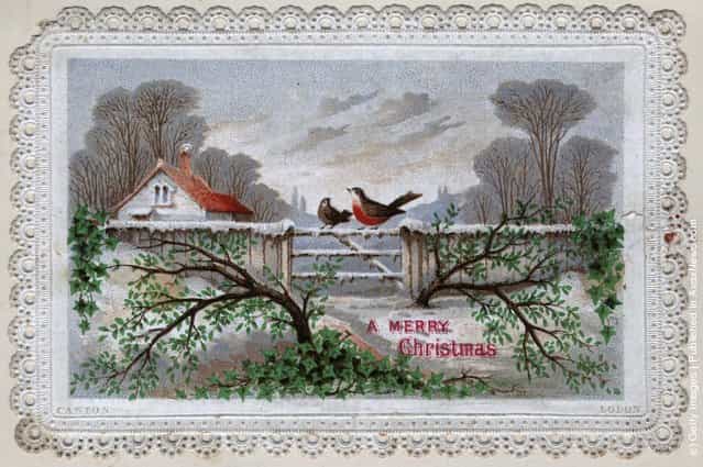 1899: A robin sitting on the gate of a house in the midst of a snow scene with a Christmas message