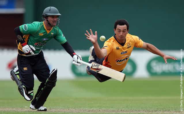 Ronald Karatiana of the Firebirds fields the ball off his own bowling while Kruger van Wyk of the Stags attempts to make his ground during the HRV Cup Twenty20 match between the Wellington Firebirds and Central Stags at Basin Reserve