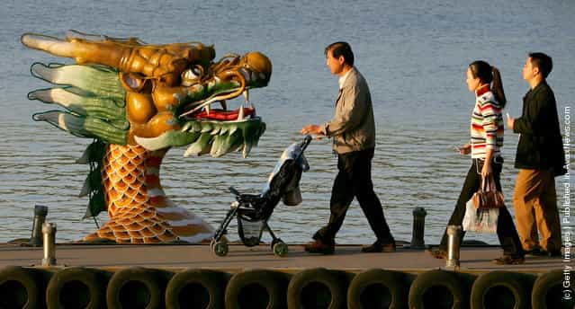 Visitors walk to a tour dragon boat on Kunming Lake at the Summer Palace