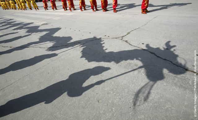 Folk artists performing a dragon dance cast a shadow on the ground during the Lantern Festival