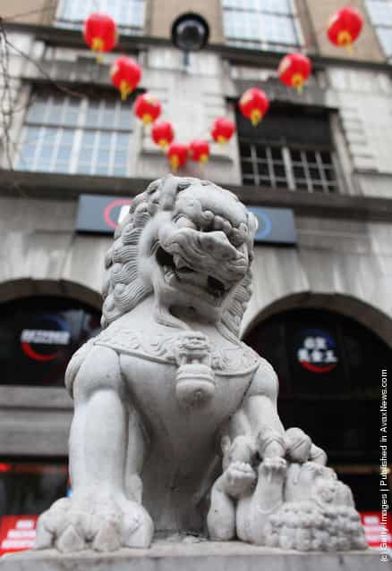 A stone Chinese dragon statue stands in the street in the Chinatown area of Westminster