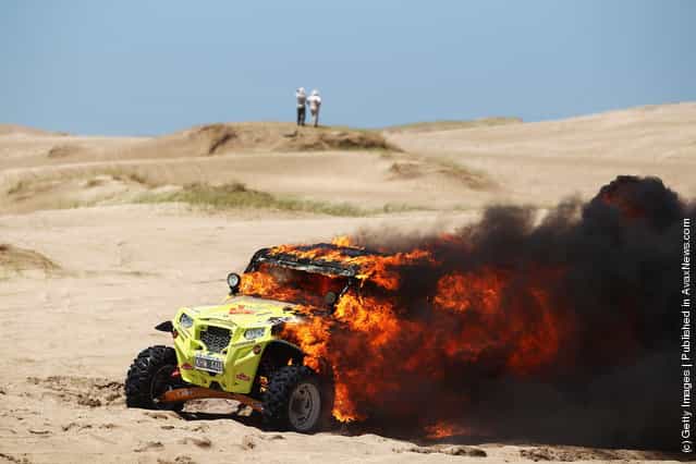 The burning Polaris of Jose Antonio Blangino of Argentina sits in the sand dunes during stage one of the 2012 Dakar Rally