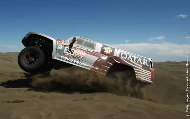 Nasser Al-Attiyah of Qatar jumps over a sand dune in his Hummer on stage two of the 2012 Dakar Rally