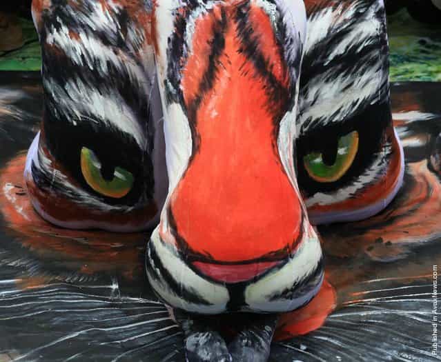A tiger is painted on the backs of three models at the Three Lanes and Seven Alleys in Fuzhou, China