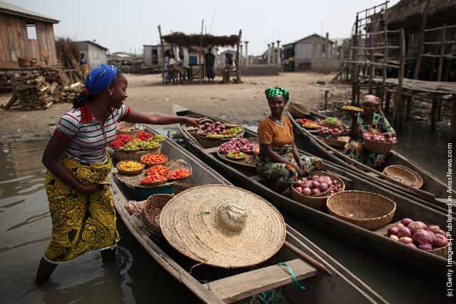 Produce including peppers, tomatoes and chillis are brought to shore by women in Ganvie, near Cotonou, Benin