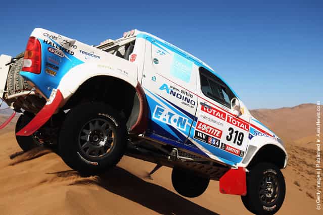 Lucio Alvarez of Argentina jumps his Toyota over a sand dune during stage seven of the 2012 Dakar Rally