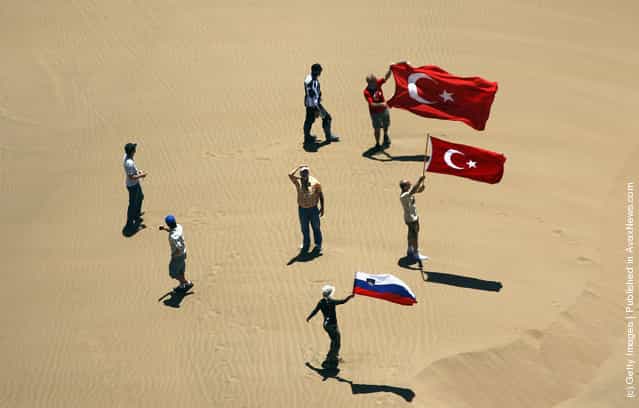Fans stand on a sand dune waiting for the competitors during stage seven of the 2012 Dakar Rally