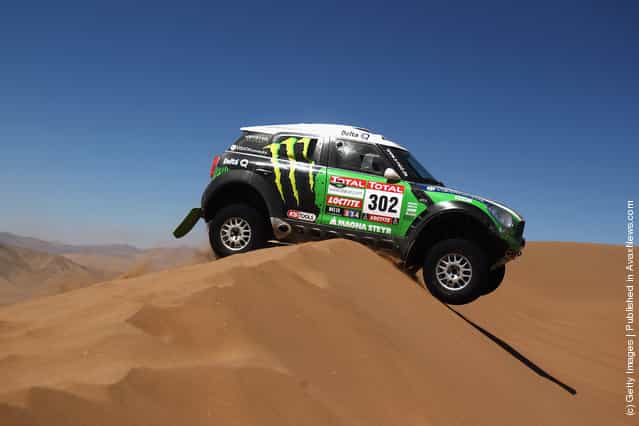Stephane Peterhansel of France drives his Mini over a sand dune during stage seven of the 2012 Dakar Rally