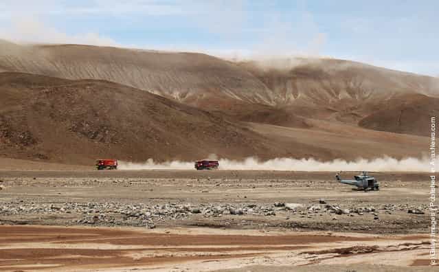 Trucks race across a valley floor during stage eight of the 2012 Dakar Rally from Copiapo to Antofagasta