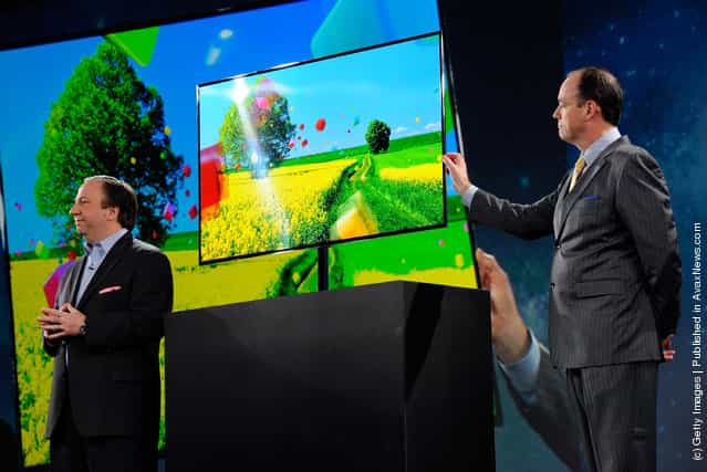 Samsung Electronics America Senior Vice President Joe Stinziano (L) and President of Consumer Electronics for Samsung Electronics America Tim Baxter show a Samsung 55-inch super OLED TV during a press event at The Venetian for the 2012 International Consumer Electronics Show