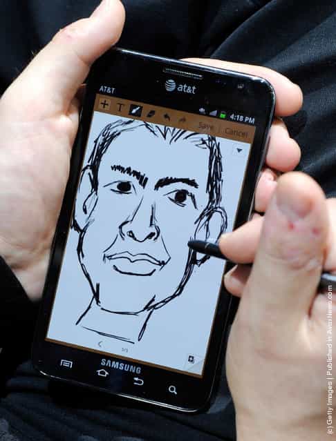 An artist draws caricatures of attendees using the Galaxy Note smartphone with integrated S Pen at the Samsung booth at the 2012 International Consumer Electronics Show