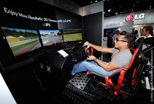 Sujhon Das of Nevada plays the Need for Speed: Shift racing video game using a racing motion machine and LG Cinema 3D IPS TVs at the LG Electronics booth at the 2012 International Consumer Electronics Show