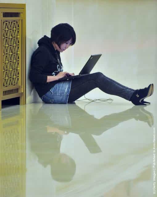 A reporter writes the news report with her laptop during a press conference