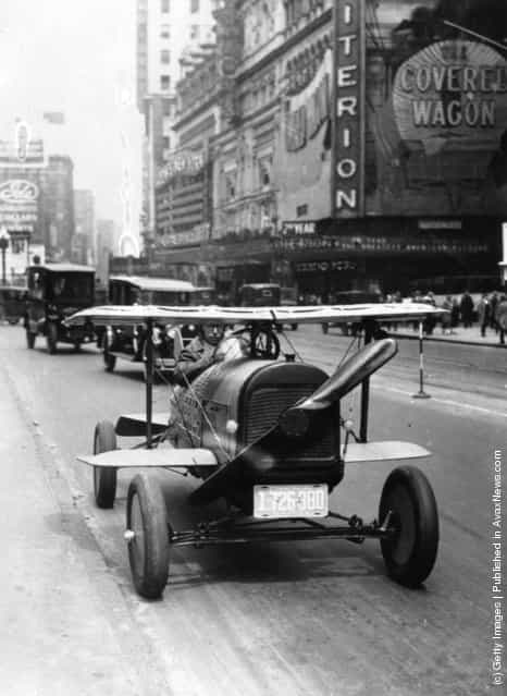 A car with wings and a propeller protruding from the radiator grille drives through Times Square, New York. The invention of A.H. Russell of Nutley, New Jersey, 1924