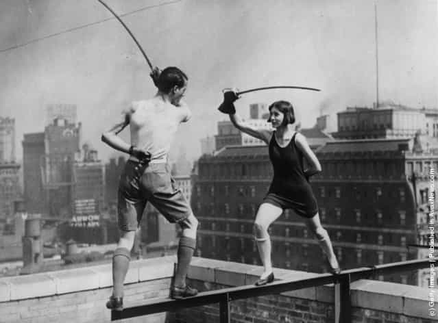 1925: Star and Isabelle Jones, of the famous theatrical Jones family, fencing on the edge of the roof of the skyscraper, Times Square Hotel