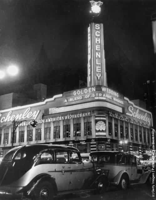1936: Schenleys, a Chinese restaurant in New Yorks Times Square, lit up at nighttime