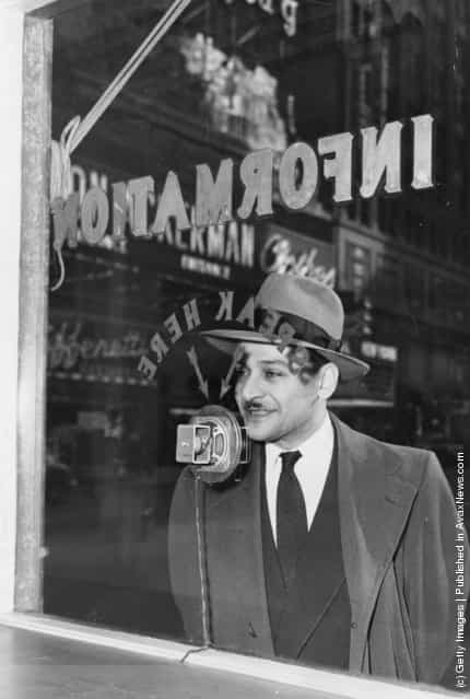 1949: An information seeker speaks into a microphone at a police information booth at Times Square, New York