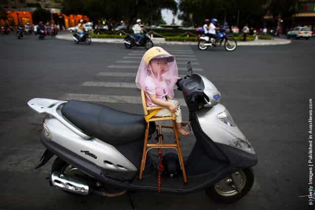 A Vietnamese girl sits on her father's new motorcycle
