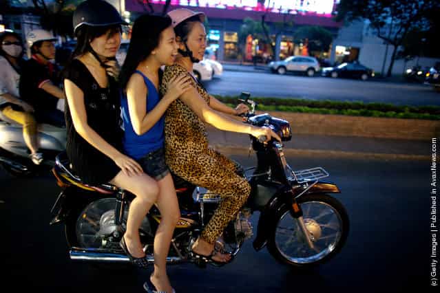 Vietnamese women cruise down the street on a motorcycle