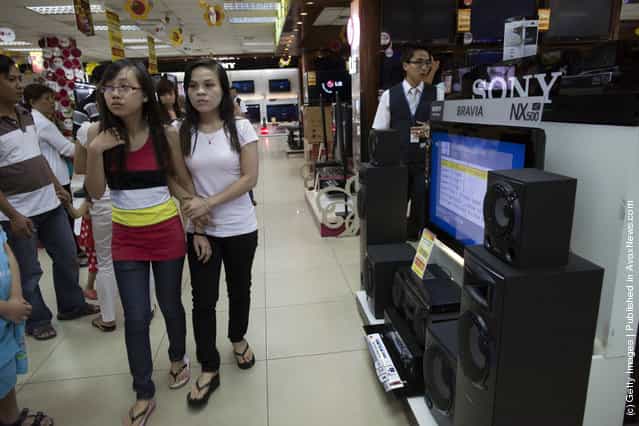 Vietnamese shoppers browse for new TV's at a electronics store