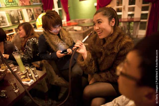 Trang Anh (R) smokes a shisha water pipe with Chinh at a local trendy bar