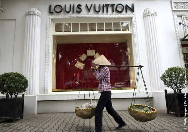 A Vietnamese woman walks by the Louis Vuitton shop in the French quarter