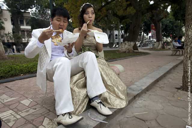 A wedding couple poses for a photographer during a wedding photo shoot