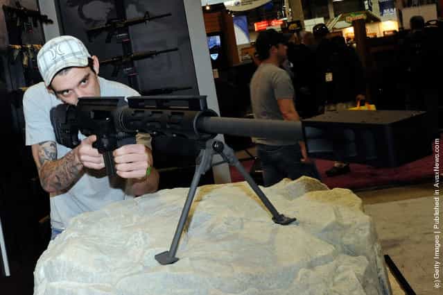 Chris Everhart looks at a Bushmaster BA-50 bolt action rifle at the Bushmaster Firearms booth at the National Shooting Sports Foundation's 34th annual Shooting, Hunting, Outdoor Trade (SHOT) Show