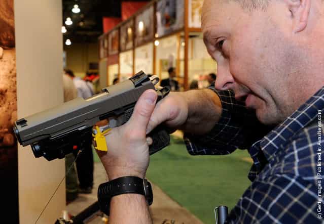 Stuart Craig of Washington tries out a Sig Sauer 1911 model Scorpion pistol at the Sig Sauer booth