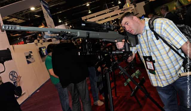 Nicholas Dugan of California looks at the new Tac-50 A1-R2 rifle on display at the McMillan Firearms Manufacturing booth