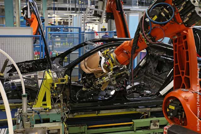 Employees mounts to a Daimler AG Mercedes-Benz S-Class vehicle on the production line