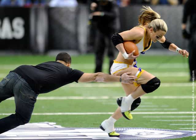 A fan tries to tackle league MVP Kyle DeHaven #1 of the Baltimore Charm during a halftime promotion at the Lingerie Football Leagues Lingerie Bowl IX between the Los Angeles Temptation and the Philadelphia Passion at the Orleans Arena