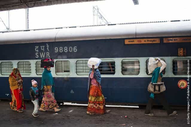 Families alight from a train at the Nizamuddin Railway Station in New Delhi, India